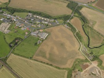 Oblique aerial view of the cropmarks of the round house and pits, taken from the SSE.