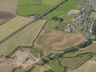 Oblique aerial view of the cropmarks of the round house and pits, taken from the E.