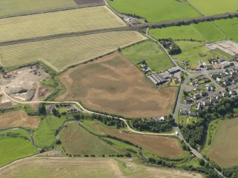 General oblique aerial view of the cropmarks of the round house and pits, taken from the NE.