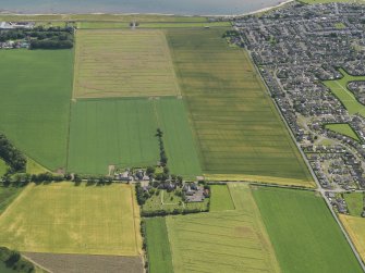 General oblique aerial view of the cropmarks of the rig with Panbride Parish Church in the foreground, taken from the NNW.