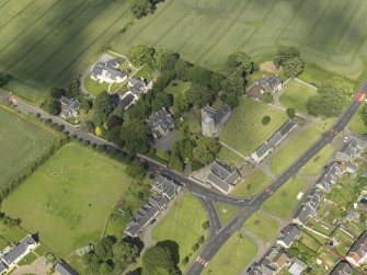 Oblique aerial view of Dalmeny centred on St Cuthbert's Church, taken from the SW.