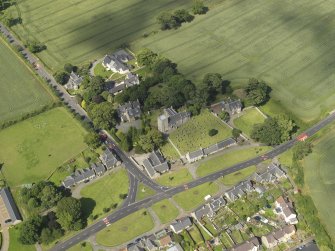 Oblique aerial view of Dalmeny centred on St Cuthbert's Church, taken from the SSW.