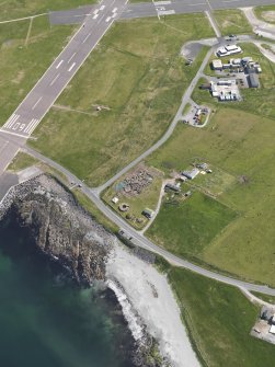 Oblique aerial view centred on the excavated broch and settlement at Old Scatness, Sumburgh, and the visitor attraction, taken from the SW.