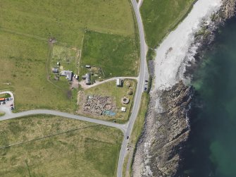 Oblique aerial view centred on the excavated broch and settlement at Old Scatness, Sumburgh, and the visitor attraction, taken from the N.