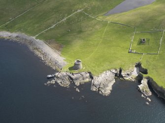 Oblique aerial view centred on the Broch of Mousa with The Haa and the burnt mound adjacent, taken from the SW.