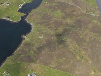 Oblique aerial view of the field system, planticrubs and buildings with the jetty and nausts beyond, looking WNW.