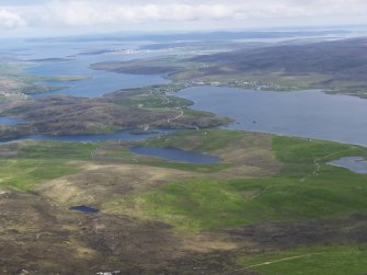 General oblique aerial view of Busta Voe and Brae village with Sullom Voe beyond, looking NE.