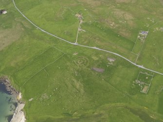 Oblique aerial view of the Broch of Underhoull and the field systems, looking NNE.