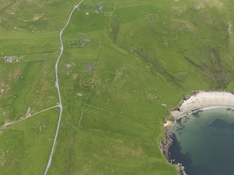 Oblique aerial view of the Broch of Underhoull and the field systems, looking SE.