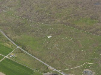 Oblique aerial view of the buildings and field systems, looking NE.