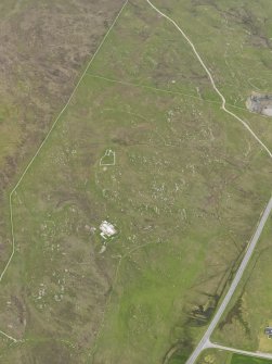 Oblique aerial view of the buildings and field systems, looking S.