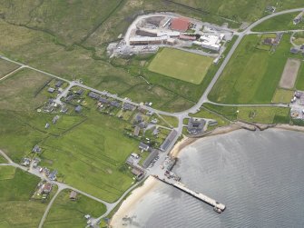 Oblique aerial view of Mid Yell centred on the pier, looking SW.