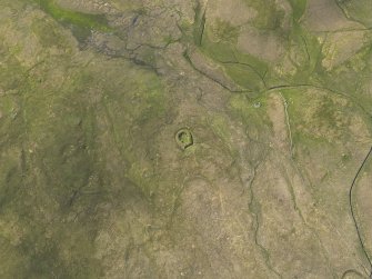 Oblique aerial view centred on the remains of the Stanydale temple, looking WNW.