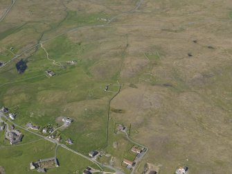 Oblique aerial view of the farmsteads and buildings, looking NNE.