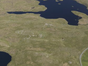 Oblique aerial view of the field systems, clearance cairns, cairns, buildings and other structures in the Loch of Flatpunds and Trolligarts area, looking SE.