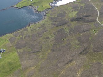 Oblique aerial view of the field systems, buildings and planticrubs, looking WSW.