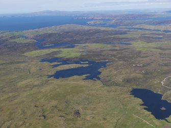 General oblique aerial view with the Upper Loch of Brouster in the foreground and the Loch of Voxterby and Brace Field in the middle distance and Burrafirth beyond, looking NNE.