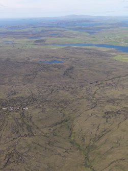 General oblique aerial view of Mid Field, Berrarunies Loch and Hagmark Hill with Effirth and Bixter Voe in the distance, looking N.