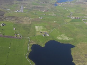 General oblique aerial view of the northern end of the Loch of Tingwall showing the Law Ting Holm with Veensgarth village and Tingwall Airport beyond, looking N.