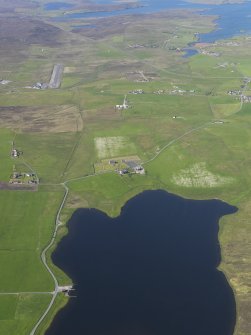 General oblique aerial view of the northern end of the Loch of Tingwall showing the Law Ting Holm with Veensgarth village and Tingwall Airport beyond, looking NNE.