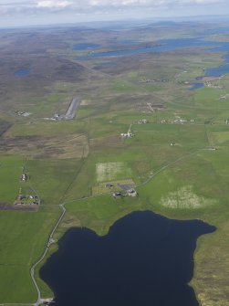 General oblique aerial view of the northern end of the Loch of Tingwall showing the Law Ting Holm with Veensgarth village and Tingwall Airport beyond, looking N.