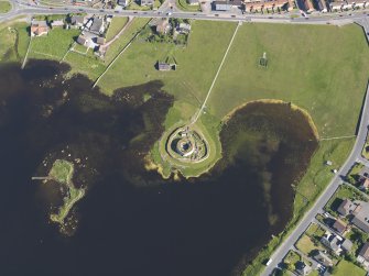 Oblique aerial view centred on the remains of the broch and settlement of Clickhimin, looking SSE.