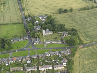 Oblique aerial view of Dalmeny centred on St Cuthbert's Church, taken from the SSE.