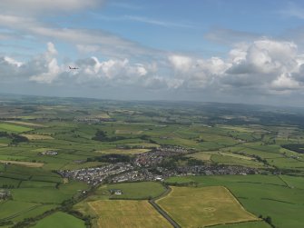 General oblique aerial view of Mossblown with a jet departing Prestwick above, taken from the WSW.