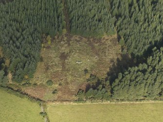 Oblique aerial view of the remains of Clune Wood Recumbent Stone Circle, taken from the SSE.