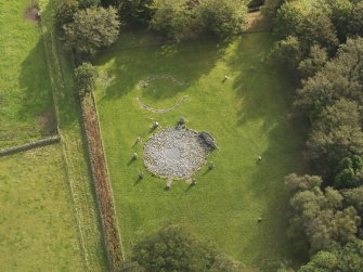 Oblique aerial view of the remains of the recumbent stone circle and enclosed cremation cemetery at Loanhead of Daviot, taken from the NW.