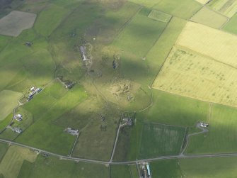 Oblique aerial view centred on the remains of the broch at Vinquin, taken from the NE.