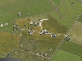 Oblique aerial view centred on the buildings of Twatt airfield, taken from the WSW.