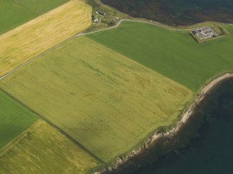 Oblique aerial view centred on the broch and souterrain at Bu, taken from the SW.