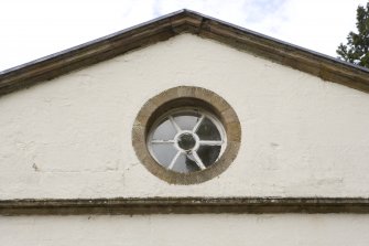 Detail of circular window in pediment on E facade