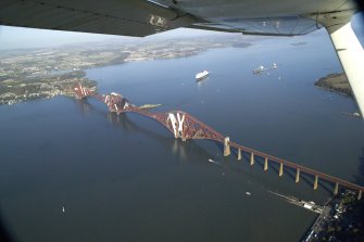 General oblique aerial view of the Forth Rail Bridge with the Queen Mary 2 in the back ground, taken from the SSW.