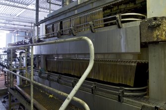 Bottling Plant. Interior. View  from north east of the pasteuriser. Two conveyor lines feed the filled and capped bottles into the two levels of the pasteurisation machine.
