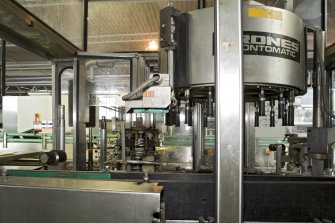 Bottling Plant. Interior. Detail view of Krones cold glue labelling machine (Prontomatic model).