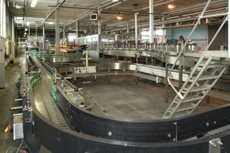 Bottling Plant. Interior. View from west  of conveyor with pasteuriser in background.