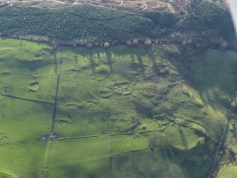 Oblique aerial view of the remains of the settlement and field boundaries, taken from the NNE.