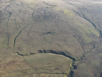 General oblique aerial view of the remains of the field boundaries, rig, farmstead, trackways, enclosure, sheepfold and possible assart, taken from the NW.