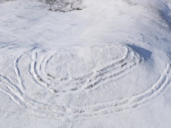 Oblique aerial view of Woden Law fort and linear earthworks in snow, looking NW.