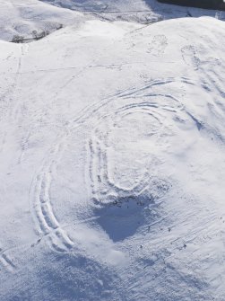 Oblique aerial view of Woden Law fort and linear earthworks in snow, looking S.