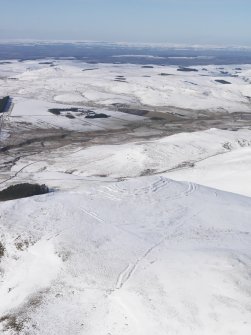 General oblique aerial view of Woden Law fort and linear earthworks in snow, looking NW