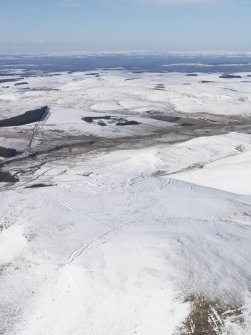 General oblique aerial view of Woden Law fort and linear earthworks in snow, looking NW.