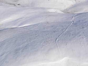 Oblique aerial view of linear earthworks under snow, looking to E.