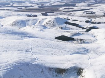 General aerial view of linear earthworks under snow, looking to W.