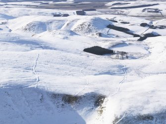 General aerial view of linear earthworks under snow, looking to W.