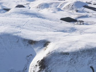 General aerial view of linear earthworks under snow, looking to W.