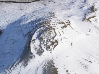 Oblique aerial view of fort, field system and rig and furrow under snow, looking to SE.