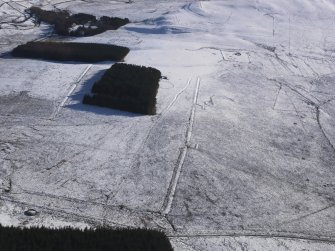 General aerial view of Roman temporary camps and linear earthwork under snow, looking to SSE.